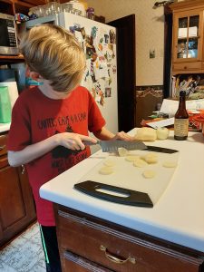 A Scout prepares his camp-style meal.