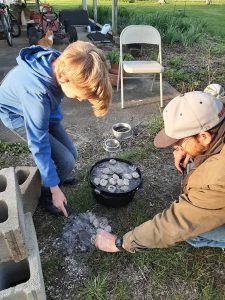 A Scout cooks a camp-style meal with his family.